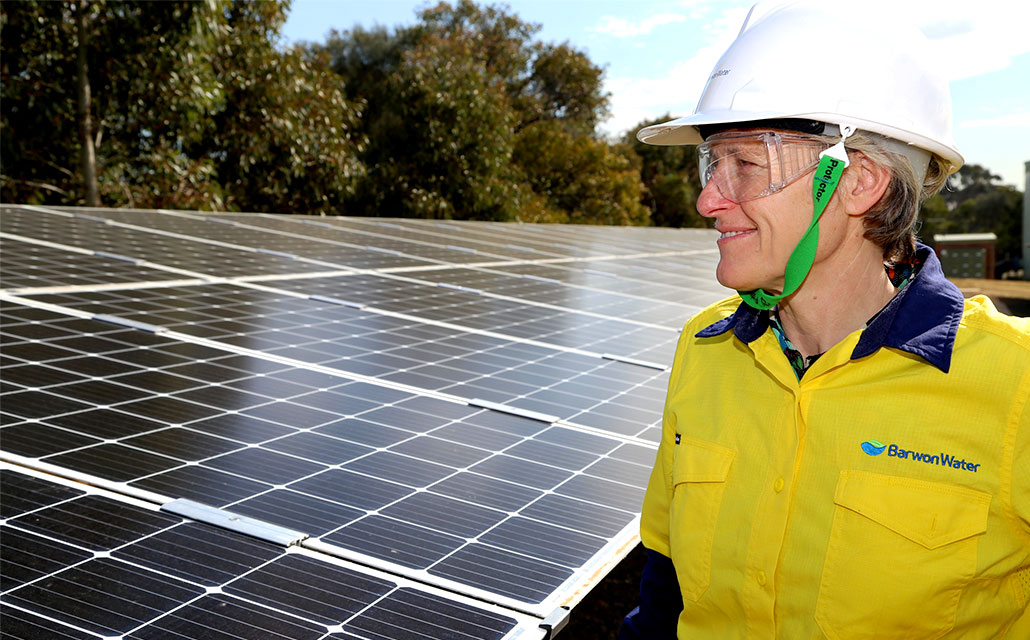 Barwon Water's managing director Tracey Slatter standing in front of SALT Torquay solar panels